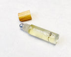 Roll-on fragrance oil bottle labeled EL3MENTS with bamboo cap on a white background