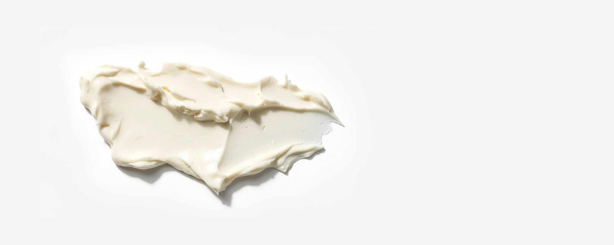 A smear of light, whipped Level 1 Moisture Riser on a plain white background.