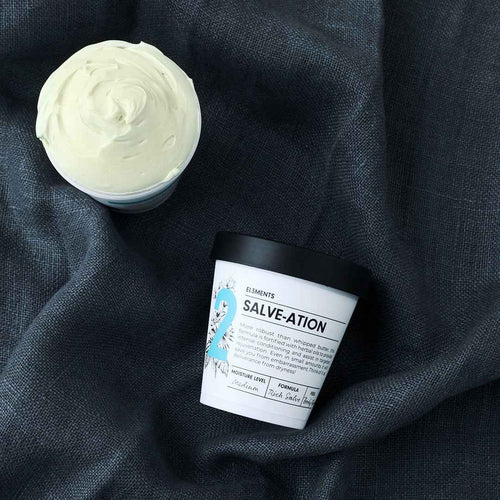 Salve-ation Body Butter jars open showing texture on grey linen background